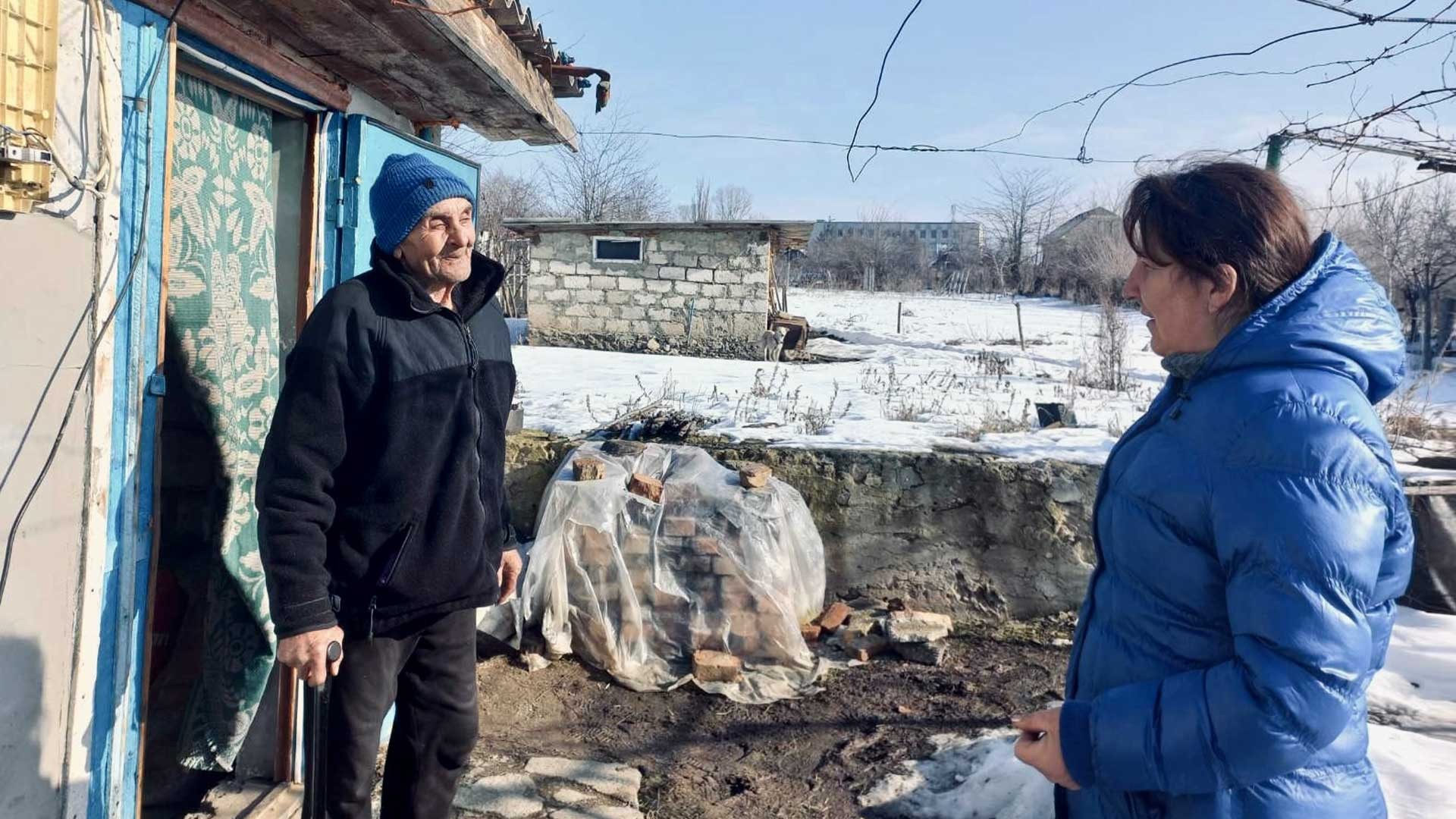 An elderly man meets a Mission coordinator at his home.