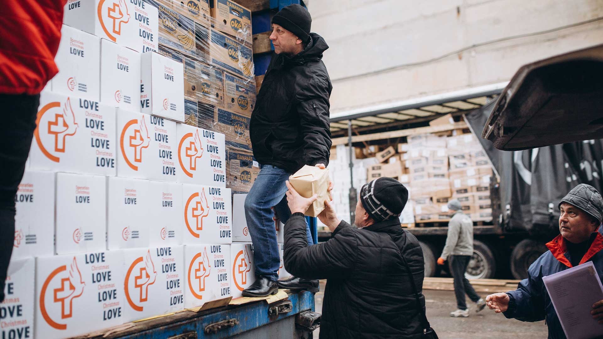 A truck containing food parcels is unloaded.