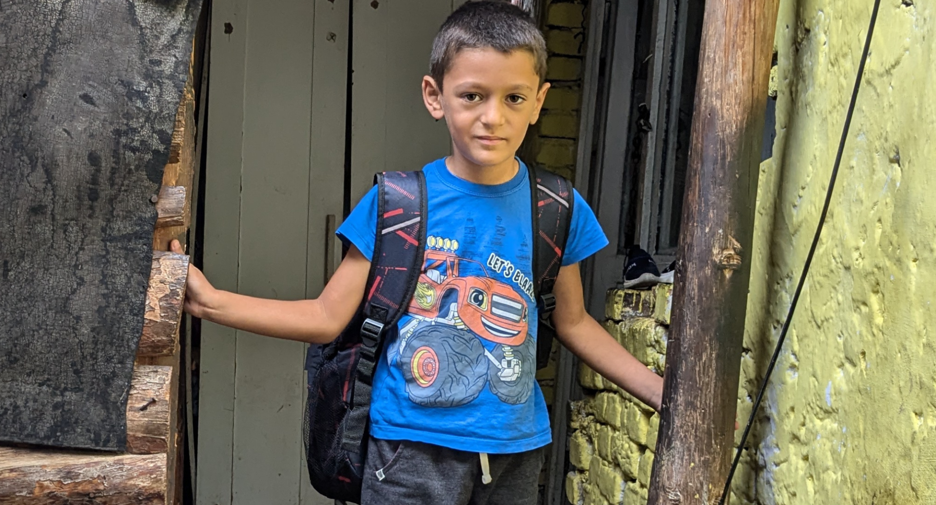 Samuli with his backpack standing in a doorway